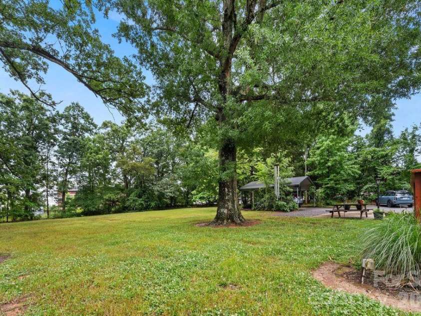 1832 Badin Road, Albemarle, NC 28001.  MLS# CAR4392071, YatesRealty ID 31414. Well maintained backyard with old growth trees.  Detached carport.
