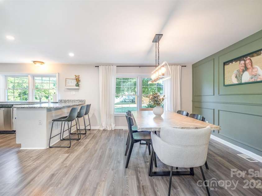 754 Rubens Road, Concord, NC 28027.  MLS# CAR4283491, YatesRealty ID 31457. Prepare to be amazed by this stunning dining room! Boasting a custom accent wall featuring rich, textured wood paneling, the space exudes warmth and character. The upgraded lighting, including sleek pendant fixtures and warm