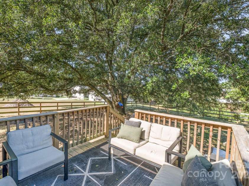 754 Rubens Road, Concord, NC 28027.  MLS# CAR4283491, YatesRealty ID 31457. This cozy deck offers stunning views of the mature canopy of trees, providing the perfect amount of shade for relaxation and enjoyment. The deck also overlooks the secure and well-maintained fenced backyard, creating a tranq
