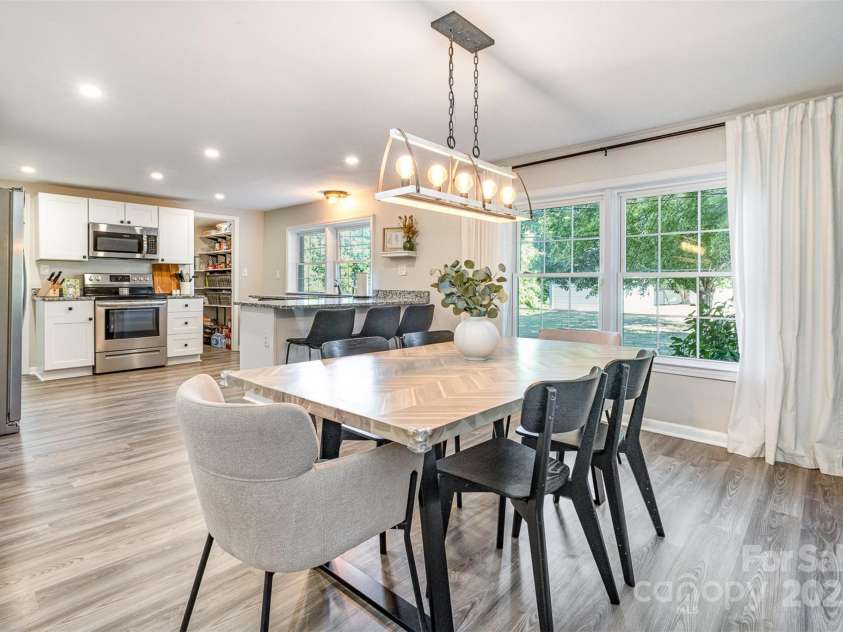 754 Rubens Road, Concord, NC 28027.  MLS# CAR4283491, YatesRealty ID 31457. This large, open-concept kitchen and dining area really delivers on a sleek, clean, and stylish design. I am particularly drawn to the beautiful white cabinets, the gleaming stainless-steel appliances, the elegant granite co