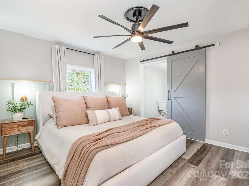 754 Rubens Road, Concord, NC 28027.  MLS# CAR4283491, YatesRealty ID 31457. This photo showcases the main bedroom, highlighting its bright and open feel. The room features nicely maintained flooring, complemented by a fresh coat of paint on the walls. A functional ceiling fan is installed for optima
