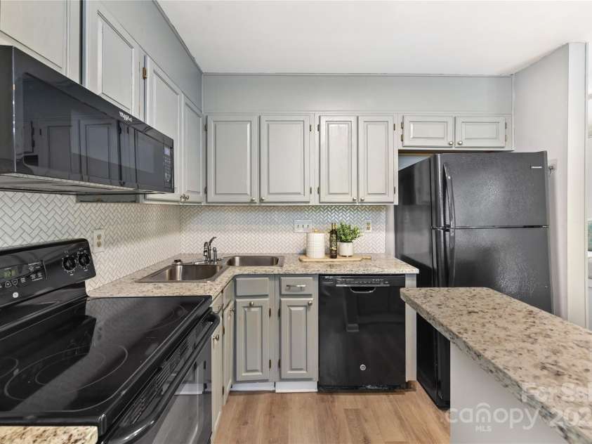 303 Northwest Drive, Davidson, NC 28036.  MLS# CAR4267438, YatesRealty ID 31490. Kitchen offers granite counters, tile back splash, painted cabinets & breakfast bar!