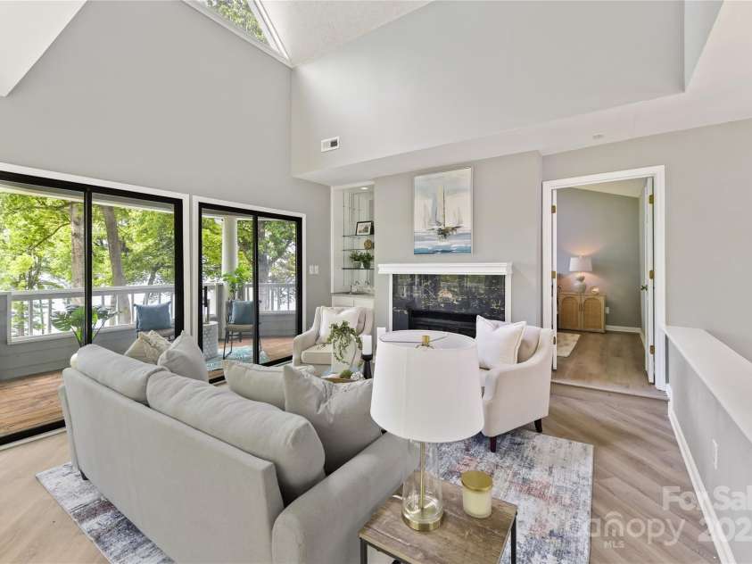 303 Northwest Drive, Davidson, NC 28036.  MLS# CAR4267438, YatesRealty ID 31490. Vaulted Great Room features wood burning fireplace, wet bar with built in glass shelving, skylight & large sliders to covered balcony with incredible Lake Norman views!