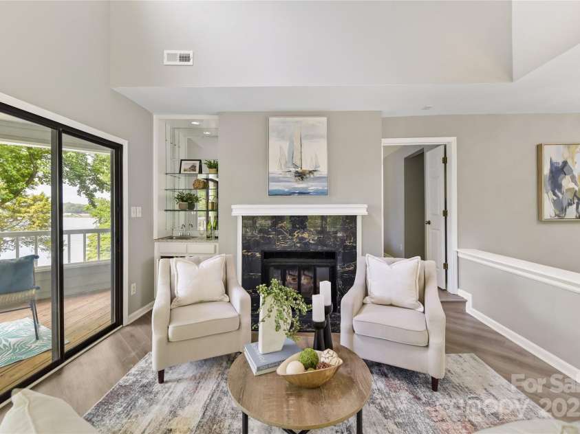 303 Northwest Drive, Davidson, NC 28036.  MLS# CAR4267438, YatesRealty ID 31490. Vaulted Great Room features wood burning fireplace, wet bar with built in glass shelving, skylight & large sliders to covered balcony with incredible Lake Norman views!