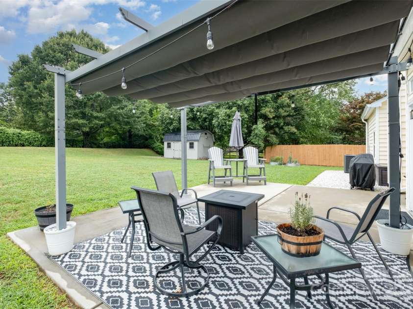 565 Viking Place, Concord, NC 28025.  MLS# CAR4288572, YatesRealty ID 31678. Enjoy this Fenced back yard under the Pergola