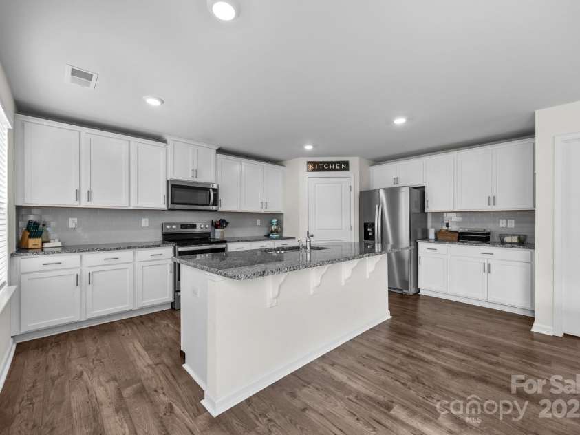 183 Marathon Lane, Candler, NC 28715.  MLS# CAR4284334, YatesRealty ID 31833. 36” birch cabinets with crown molding, sleek granite countertops, and island seating in the kitchen.