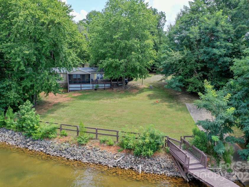 136 Buttercup Drive, Mooresville, NC 28117.  MLS# CAR4284193, YatesRealty ID 31853. Easy slopped lot with fenced yard and your own private boat ramp.