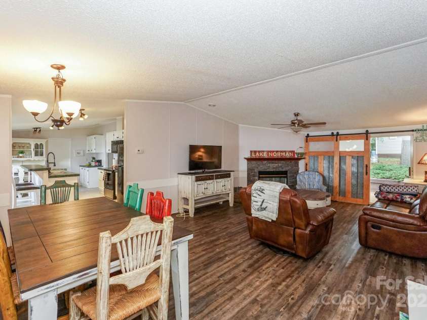 136 Buttercup Drive, Mooresville, NC 28117.  MLS# CAR4284193, YatesRealty ID 31853. From the dining area you can also entertain in the living room with gas fireplace and open the barn door for more light.