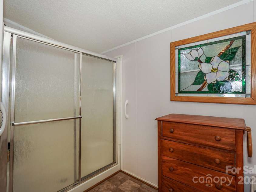 136 Buttercup Drive, Mooresville, NC 28117.  MLS# CAR4284193, YatesRealty ID 31853. Primary bathroom with stained glass windows and step in shower.