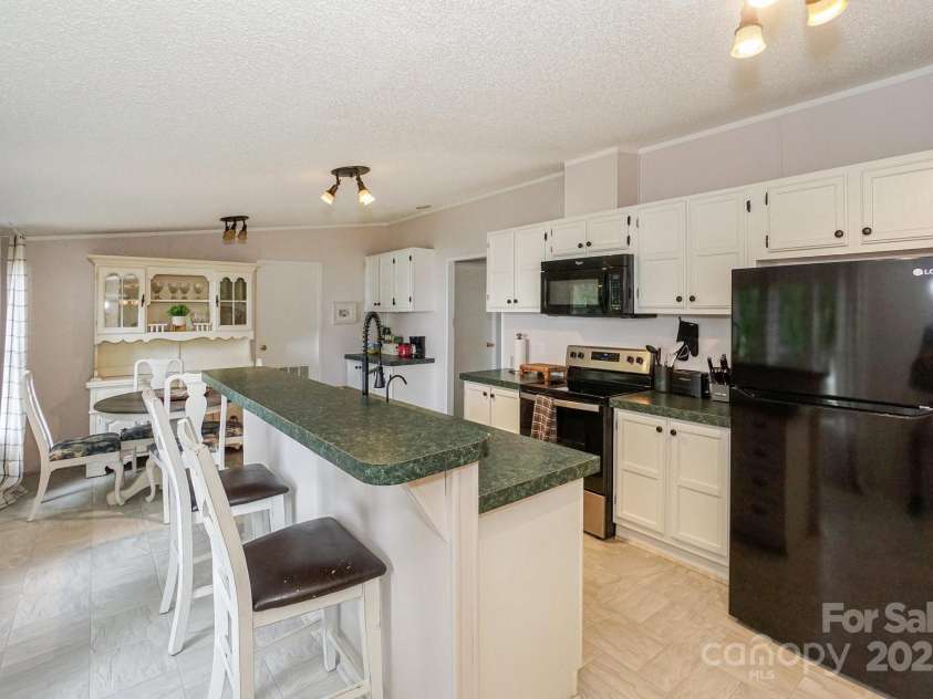 136 Buttercup Drive, Mooresville, NC 28117.  MLS# CAR4284193, YatesRealty ID 31853. Renovated kitchen has large island with pull up bar stool seating as well as an eat-in breakfast area.