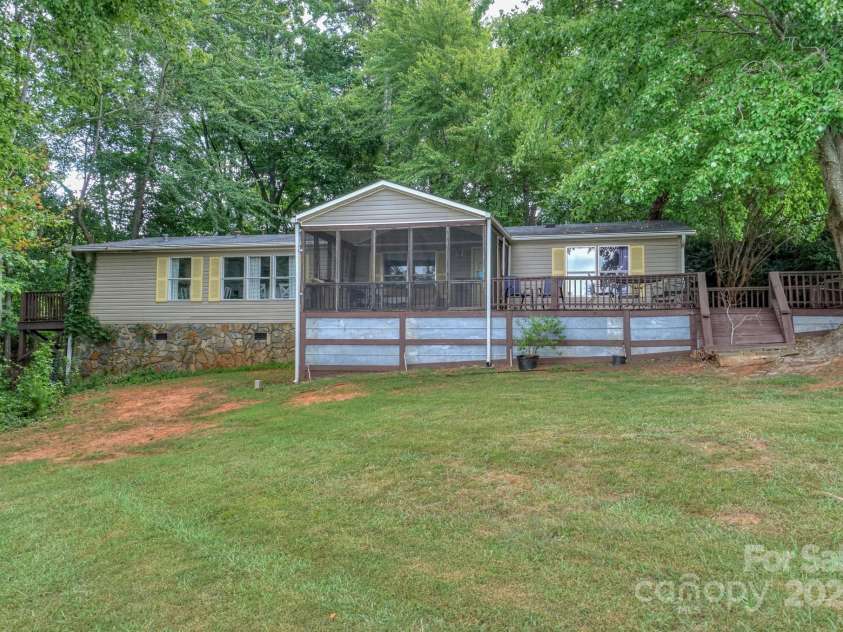 136 Buttercup Drive, Mooresville, NC 28117.  MLS# CAR4284193, YatesRealty ID 31853. View of the home with a screened front porch and additional deck for watching the lake.
