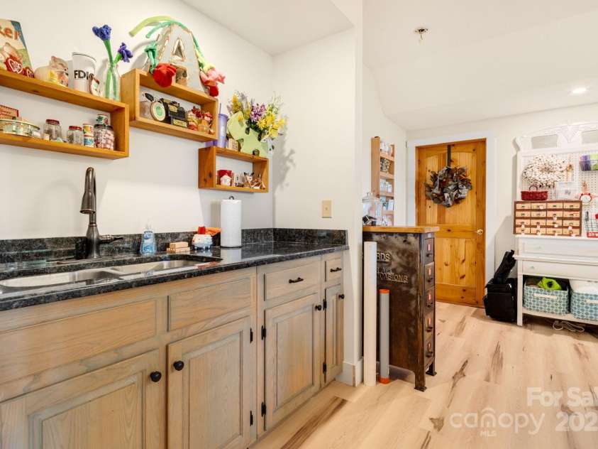 492 Henry Mountain Road, Brevard, NC 28712.  MLS# CAR4278583, YatesRealty ID 31855. Basement cabinet with sink.  Door leading to the unfinished portion of basement.