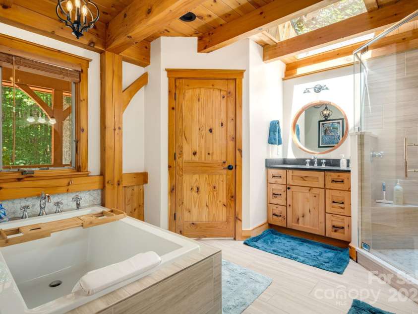 492 Henry Mountain Road, Brevard, NC 28712.  MLS# CAR4278583, YatesRealty ID 31855. Primary bath includes tub, shower, double vanities, and a water closet.