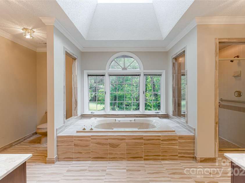 2011 Barden Road, Charlotte, NC 28226.  MLS# CAR4278483, YatesRealty ID 31858. Large bathroom with jetted tub and a view of the private back yard.