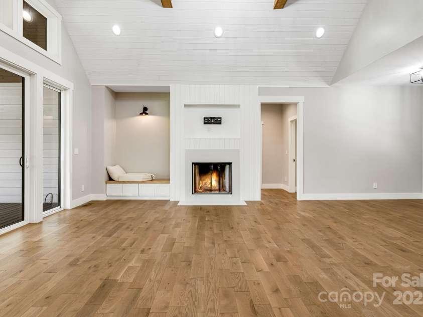 111 Oak Mountain Drive, Leicester, NC 28748.  MLS# CAR4289425, YatesRealty ID 31920. Living room features valuted ceilings and cozy wood-burning fireplace