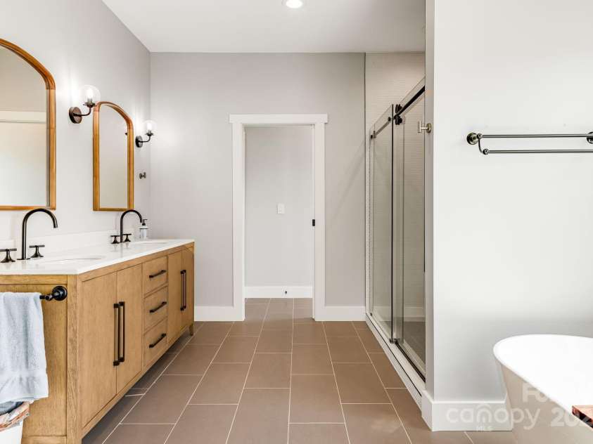 111 Oak Mountain Drive, Leicester, NC 28748.  MLS# CAR4289425, YatesRealty ID 31920. Spa-like primary bedroom with double vanity, walk-in shower, and soaking tub