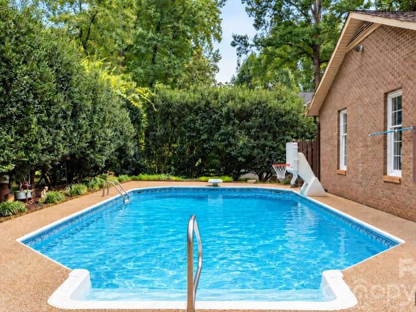 3110 Ninth Tee Drive, Newton, NC 28658.  MLS# CAR4427024, YatesRealty ID 31959. Pool shown uncovered, AI generated image from owner's photos showing pool open last season