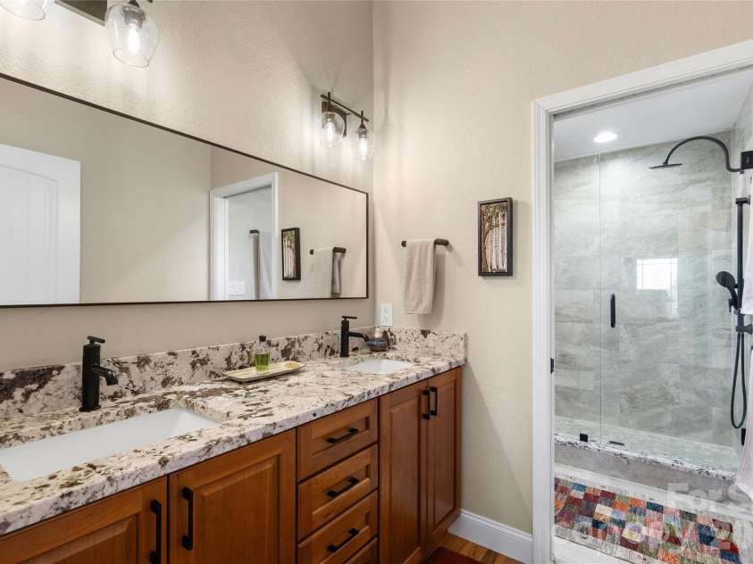 34 Justice Drive, Leicester, NC 28748.  MLS# CAR4394117, YatesRealty ID 31989. En-suite primary bathroom with cherry cabinets, double vanity with granite counters 