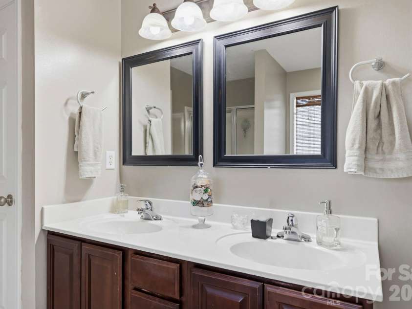266 Wildbriar Road, Fletcher, NC 28732.  MLS# CAR4394463, YatesRealty ID 32005. Spacious double-sink vanity with framed mirrors, ample counter space, and functional storage cabinetry in the primary bathroom.
