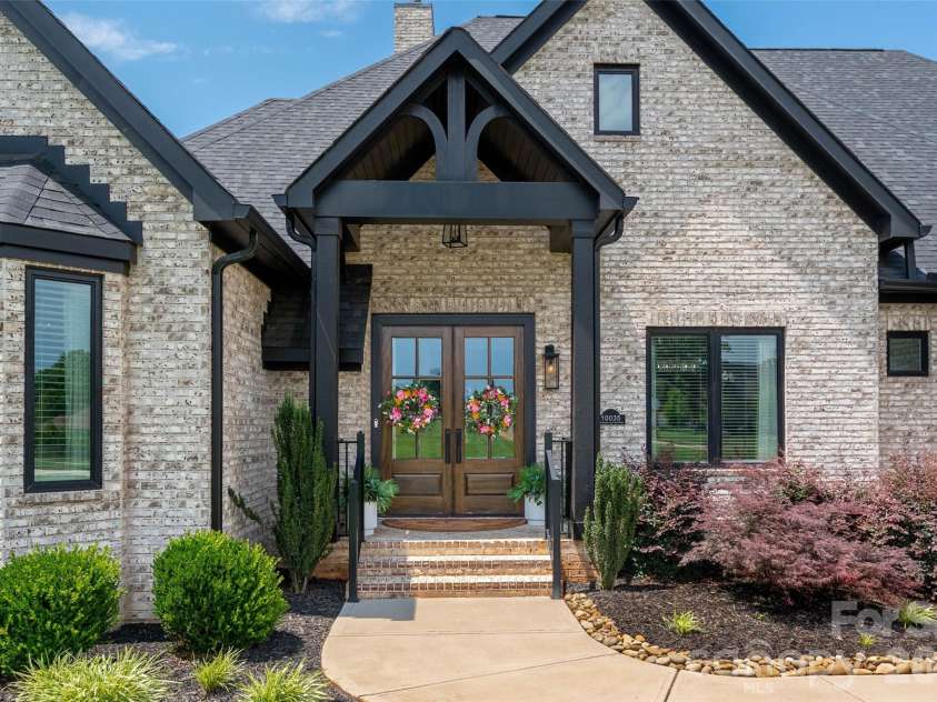 10035 Whispering Falls Avenue, Charlotte, NC 28227.  MLS# CAR4393646, YatesRealty ID 32047. Impressive double 8-foot entry doors with beautiful landscaping