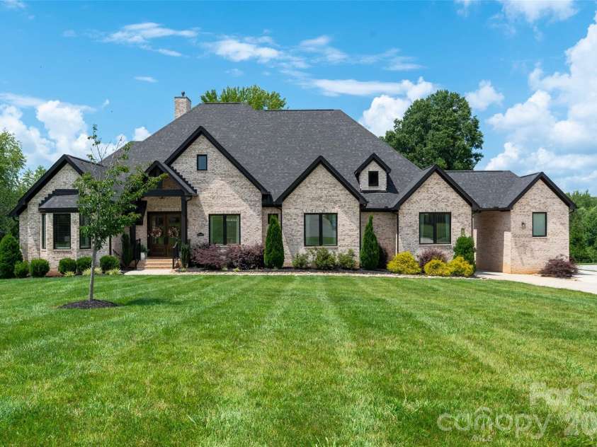 10035 Whispering Falls Avenue, Charlotte, NC 28227.  MLS# CAR4393646, YatesRealty ID 32047. Showcasing a timeless brick exterior, exceptional curb appeal, and an expansive manicured front lawn