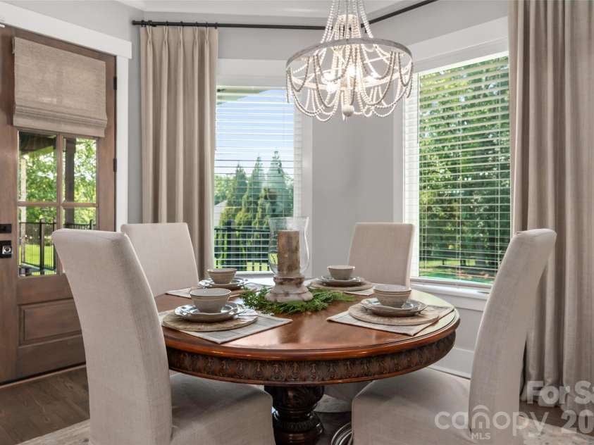 10035 Whispering Falls Avenue, Charlotte, NC 28227.  MLS# CAR4393646, YatesRealty ID 32047. The breakfast nook is framed by large windows that overlook the expansive backyard, filling the space with natural light and serene outdoor views.