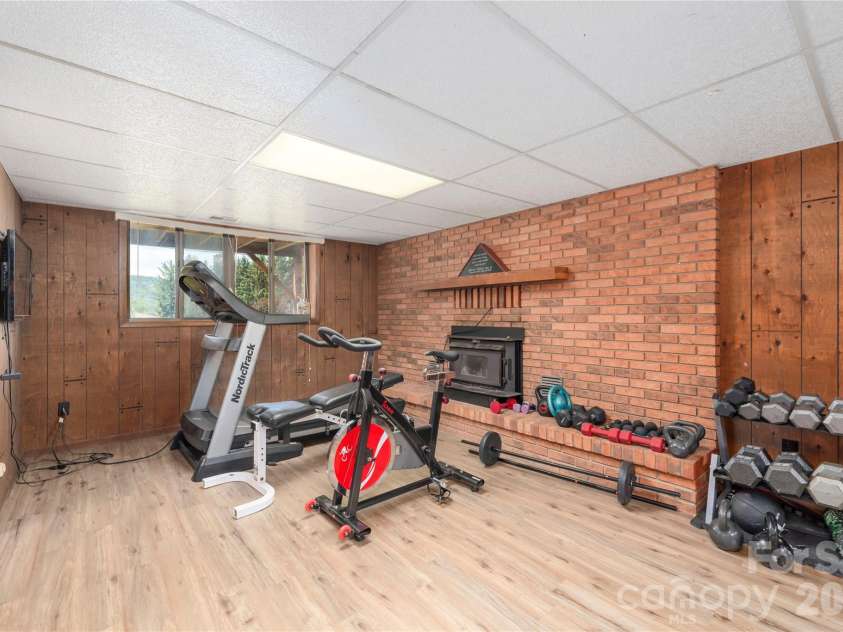 99 Young Drive, Candler, NC 28715.  MLS# CAR4388636, YatesRealty ID 32054. Lower level den with brick fireplace