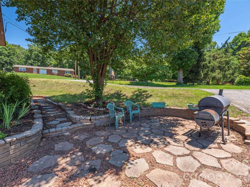 99 Young Drive, Candler, NC 28715.  MLS# CAR4388636, YatesRealty ID 32054. Shaded sitting area with fire pit and grilling options
