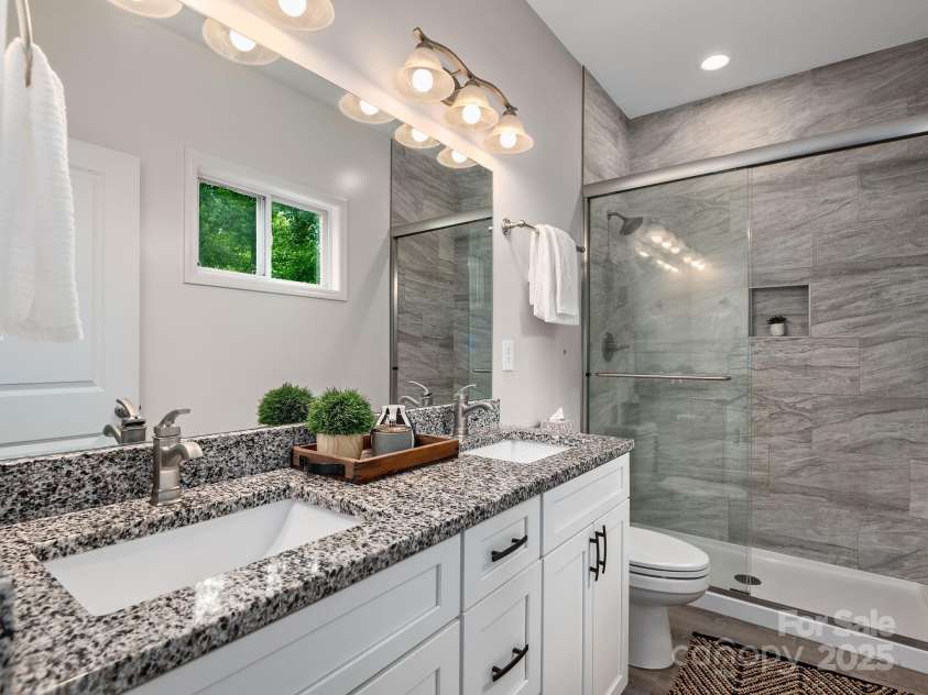 111 Mears Ridge Drive, Asheville, NC 28806.  MLS# CAR4265315, YatesRealty ID 32084. Spa-inspired primary bathroom with floor-to-ceiling tiled walk in shower