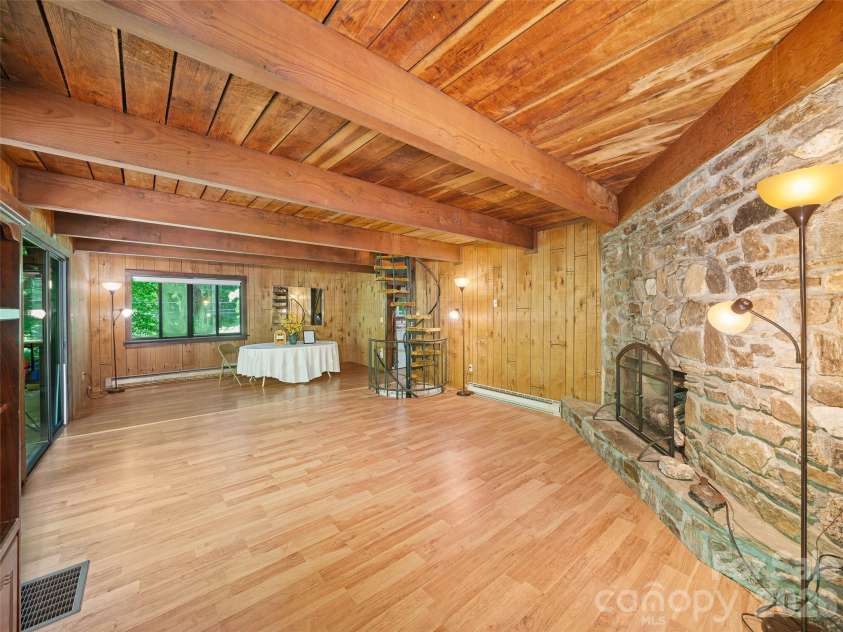 552 Fork Road, Burnsville, NC 28714.  MLS# CAR4395564, YatesRealty ID 32097. Greatroom and dining room-large rock fireplace 