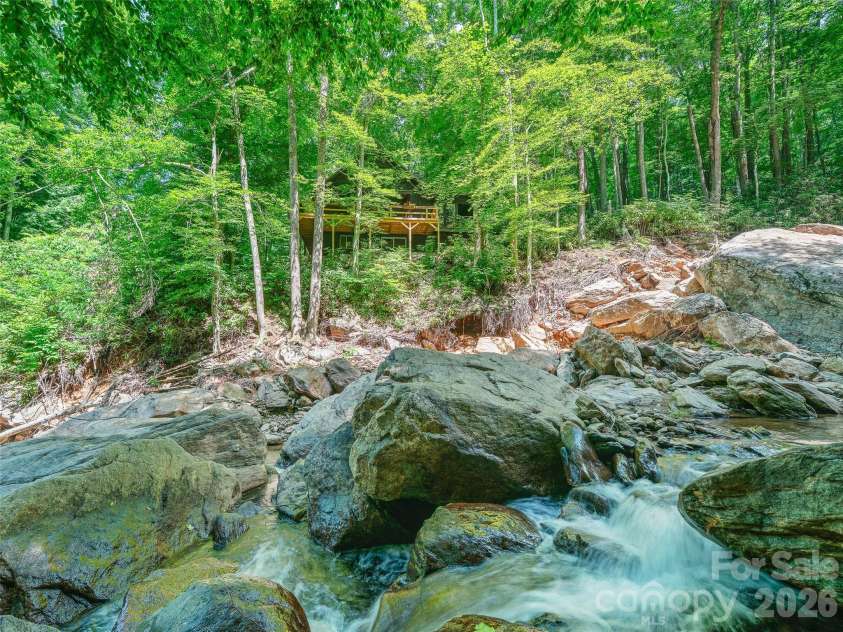 552 Fork Road, Burnsville, NC 28714.  MLS# CAR4395564, YatesRealty ID 32097. Large boulders create casading waters flowing around and through . Two beaches down by the water with pathways leading down to them for access.  