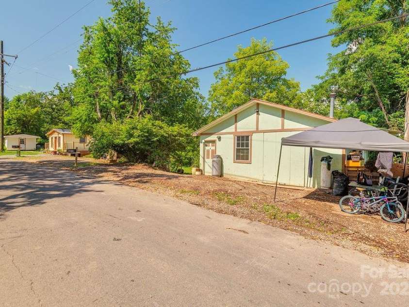 153 Vinewood Circle, Asheville, NC 28806.  MLS# CAR4278803, YatesRealty ID 32113. View of the property from the street.  Workshop and shed on opposite ends of the street frontage.  Parking spots all along road.