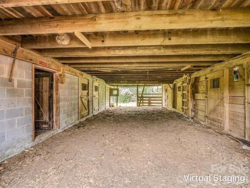 54 Old Lime Kiln Road, Arden, NC 28704.  MLS# CAR4394473, YatesRealty ID 32159. Lower barn area with multiple stalls and tack room barn virtually shown as empty.