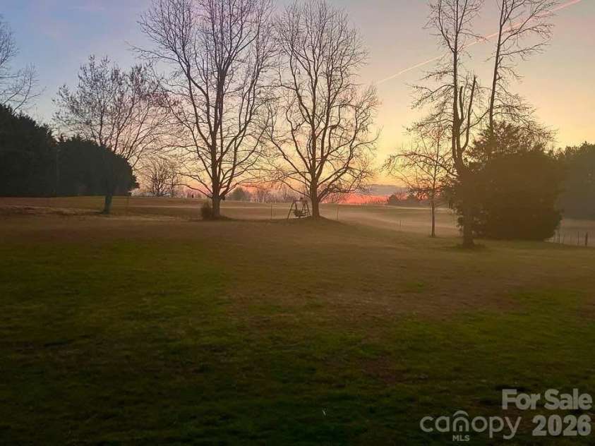 505 Glover Road, Ellenboro, NC 28040.  MLS# CAR4390843, YatesRealty ID 32171. Back Yard Twilight View