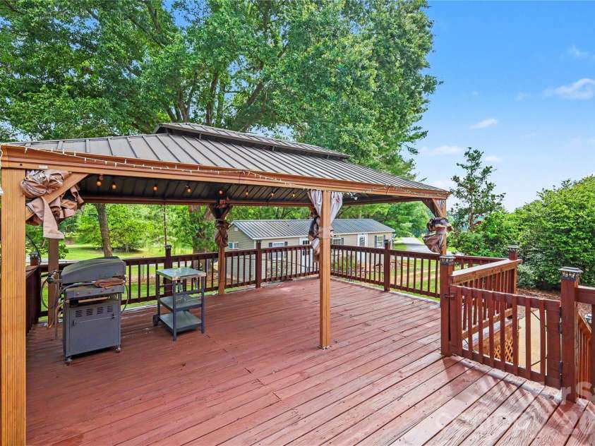 3035 River Road, Shelby, NC 28152.  MLS# CAR4393032, YatesRealty ID 32187. Immediately off the kitchen and dining area is a huge deck with gazebo cover that includes remote controlled fans and heater AND a hard piped gas-fueled Blackstone griddle!