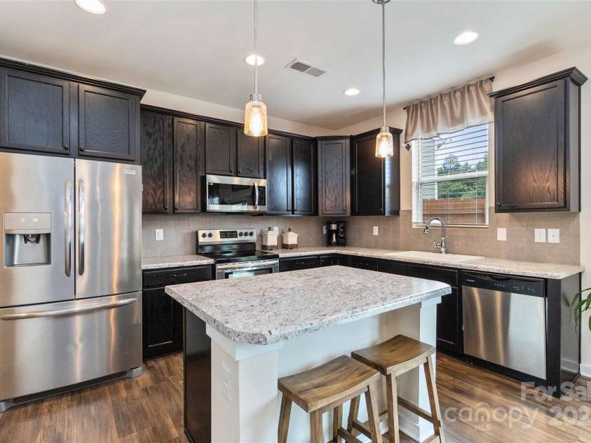 4626 Gibbons Link Road, Charlotte, NC 28269.  MLS# CAR4290378, YatesRealty ID 32205. Stylish kitchen featuring stainless steel appliances, tiled backsplash, and central island