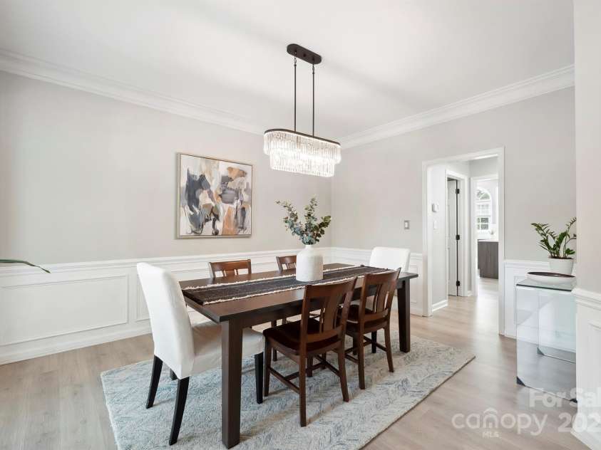 21203 Harken Drive, Cornelius, NC 28031.  MLS# CAR4253186, YatesRealty ID 32227. Formal Dining Room features crown molding, wainscoting, custom light fixture & beautiful bay window with plantation shutters!