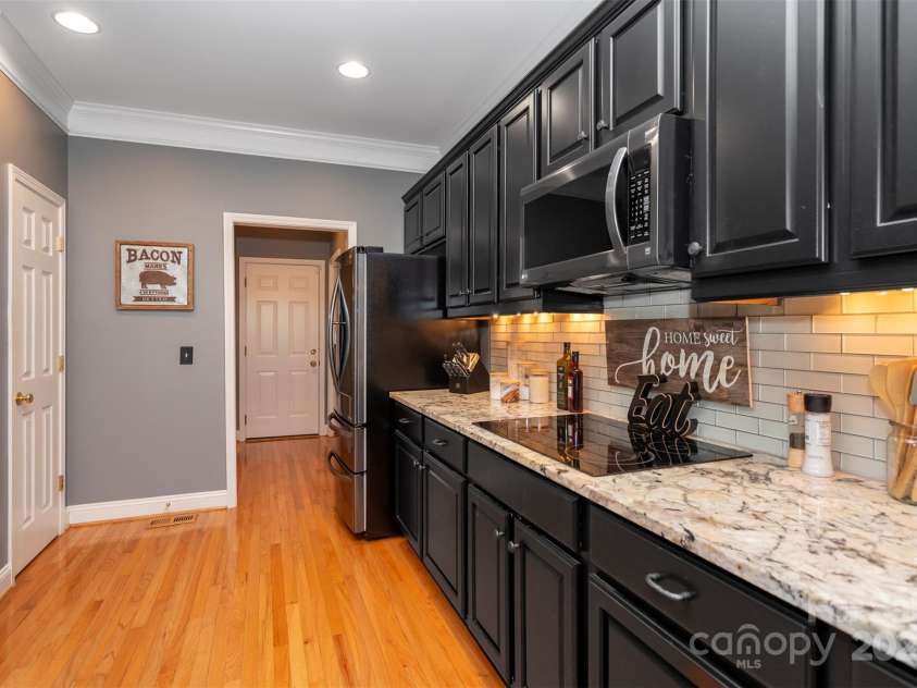 126 Doyle Farm Lane, Mooresville, NC 28115.  MLS# CAR4270254, YatesRealty ID 32228. Updated Kitchen featuring gorgeous     natural granite counters, dual oven, smooth top electric cooktop, 42” under lit cabinets and breakfast bar.