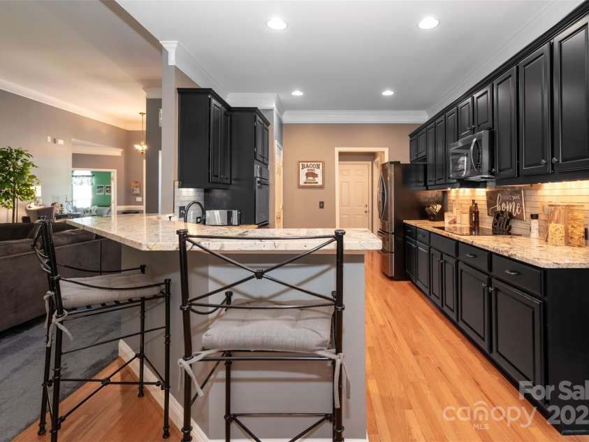126 Doyle Farm Lane, Mooresville, NC 28115.  MLS# CAR4270254, YatesRealty ID 32228. Updated Kitchen featuring gorgeous     natural granite counters, dual oven, smooth top electric cooktop, 42” under lit cabinets and breakfast bar.