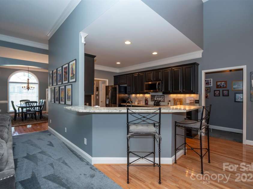 126 Doyle Farm Lane, Mooresville, NC 28115.  MLS# CAR4270254, YatesRealty ID 32228. Updated Kitchen featuring gorgeous     natural granite counters, dual oven, smooth top electric cooktop, 42” under lit cabinets and breakfast bar.