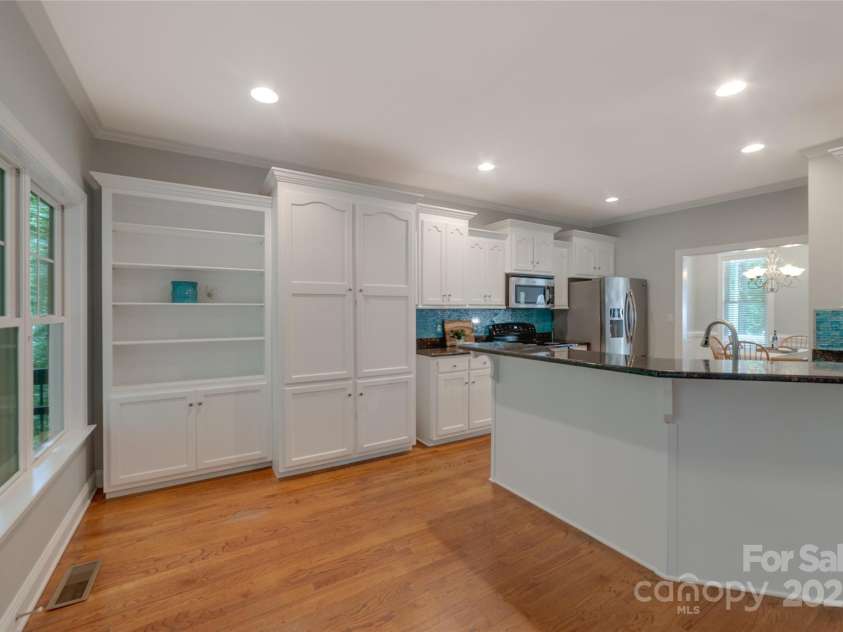 6414 Winding Creek Lane, Denver, NC 28037.  MLS# CAR4240521, YatesRealty ID 32247. Kitchen with white cabinets, tile backsplash and built-ins