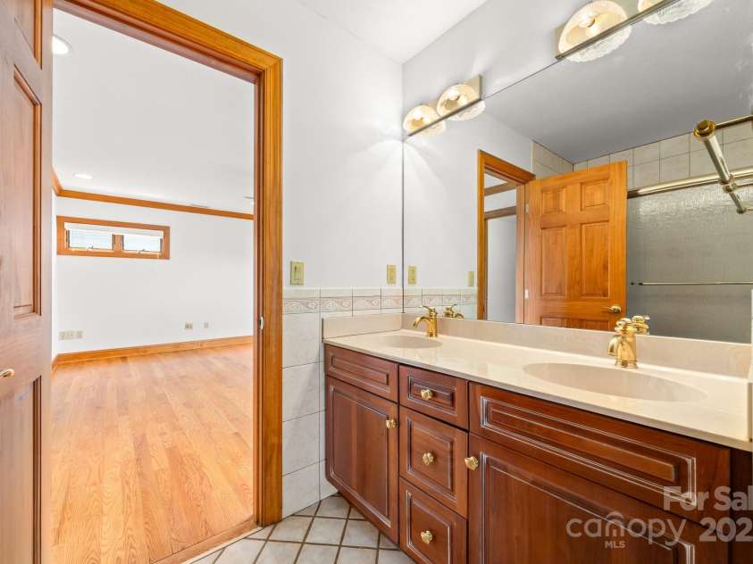 117 Distant View Drive, Asheville, NC 28803.  MLS# CAR4253814, YatesRealty ID 3225. Middle level bathroom with dual vanity and tub/shower insert.