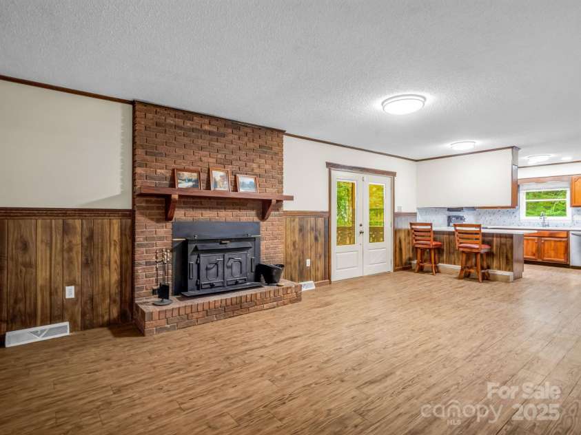 612 Buckeye Cove Road, Swannanoa, NC 28778.  MLS# CAR4287108, YatesRealty ID 32265. Cozy den with woodburning fireplace, French doors leading out to the screened patio.