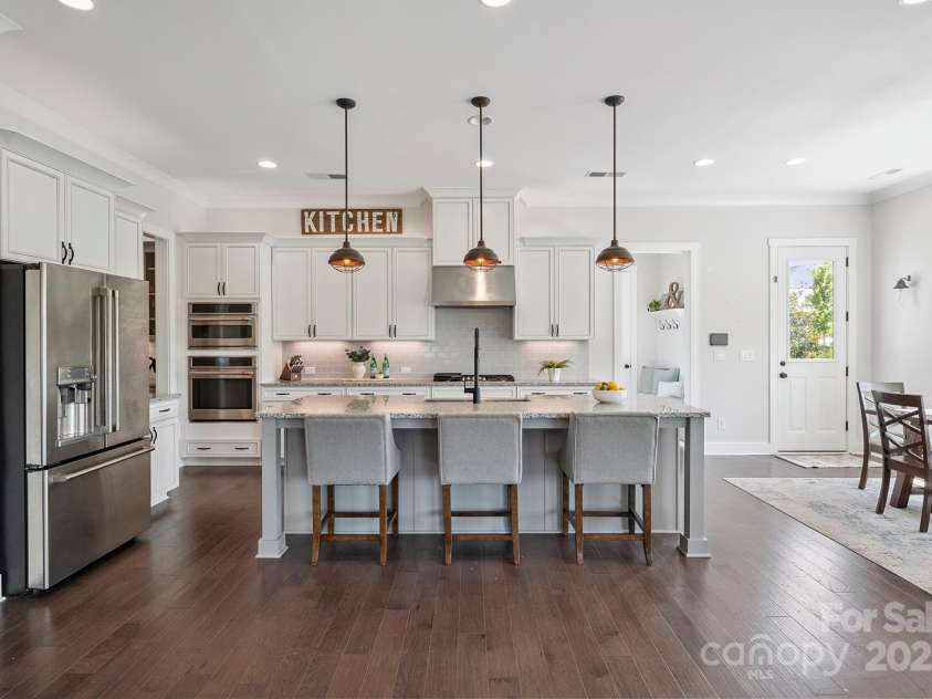 19012 Beecher Commons Drive, Huntersville, NC 28078.  MLS# CAR4276383, YatesRealty ID 32273. Gourmet Kitchen offers stainless steel appliances, granite counters, large center island with seating & storage, custom lighting including under cabinet, tile back splash, gas cook top, wall oven, butler's p