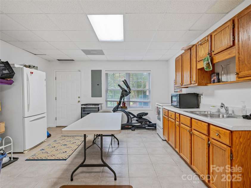808 Old Fort Road, Fairview, NC 28730.  MLS# CAR4281084, YatesRealty ID 32308. The lower level open floor plan features a kitchen with stove and refrigerator.