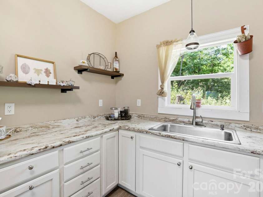 106 Thistle Field Drive, Asheville, NC 28806.  MLS# CAR4395368, YatesRealty ID 32315. Functional kitchen workspace with ample counter space, white cabinetry, open shelving, and attractive natural views.