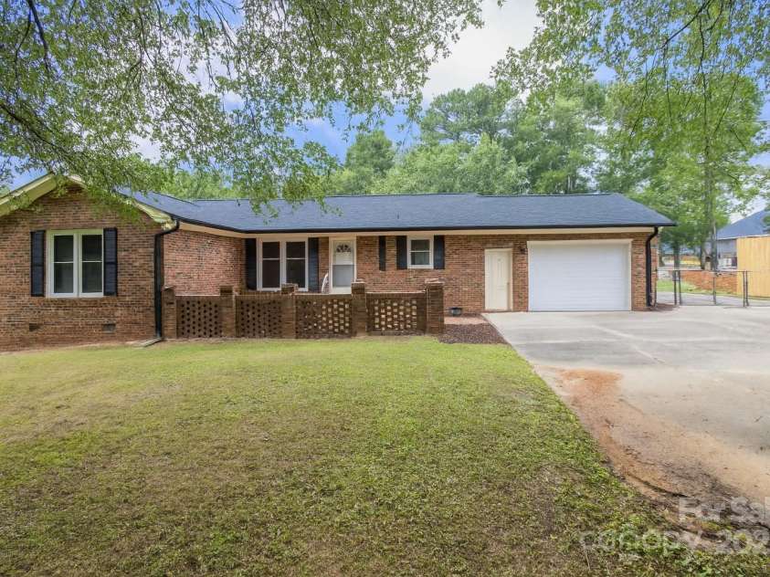 687 Tryon Place, Gastonia, NC 28054.  MLS# CAR4278855, YatesRealty ID 32315. Back view of home with brick court yard and entrance to garage