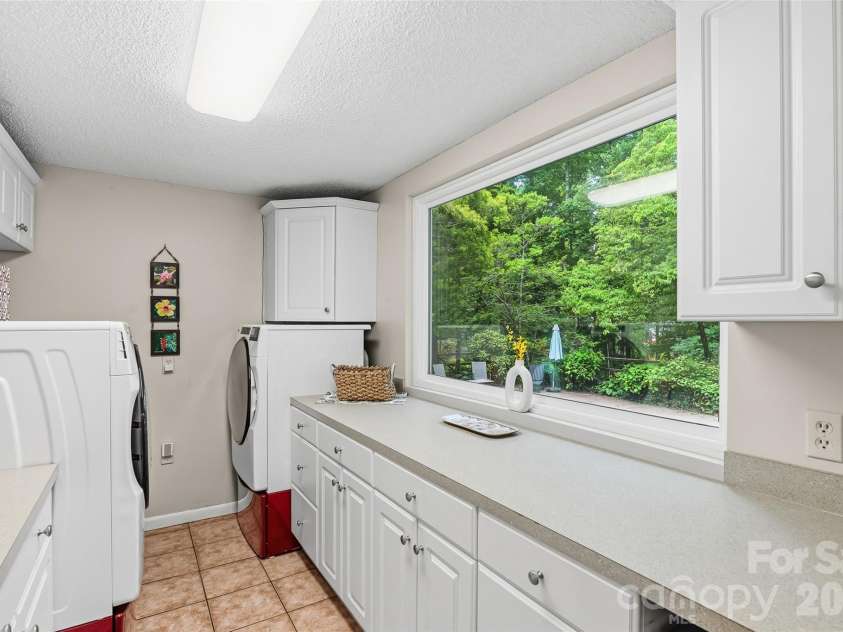 16 Canterbury Drive, Arden, NC 28704.  MLS# CAR4396207, YatesRealty ID 32349. Large laundry overlooks the pool area - so much storage