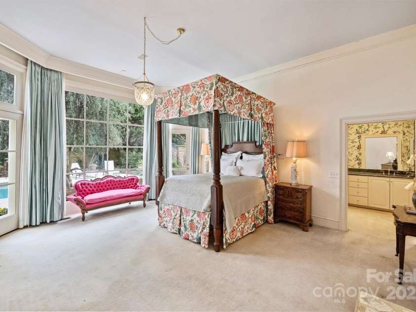 318 Canterbury Road, Charlotte, NC 28211.  MLS# CAR4231857, YatesRealty ID 3238. The main level hosts the primary suite, architecturally mirrored with the dining room, featuring floor-to-ceiling bay windows, a spacious ensuite bathroom, and dual cedar walk-in closets.