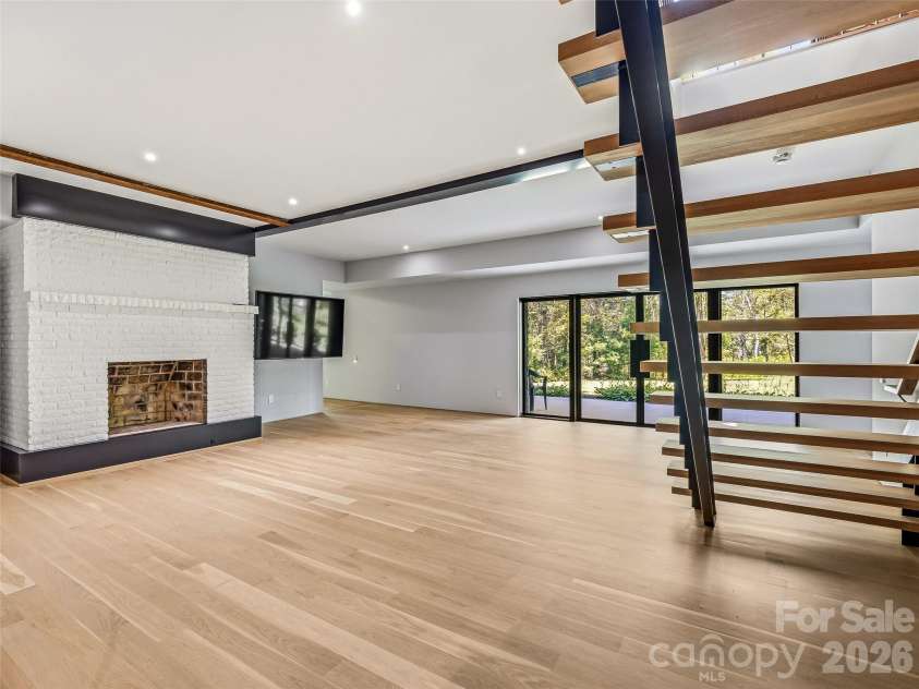 3 Holly Hill Road, Biltmore Forest, NC 28803.  MLS# CAR4396733, YatesRealty ID 32435. The fully finished lower level includes a cozy secondary den with minimalistic flush face fireplace.
